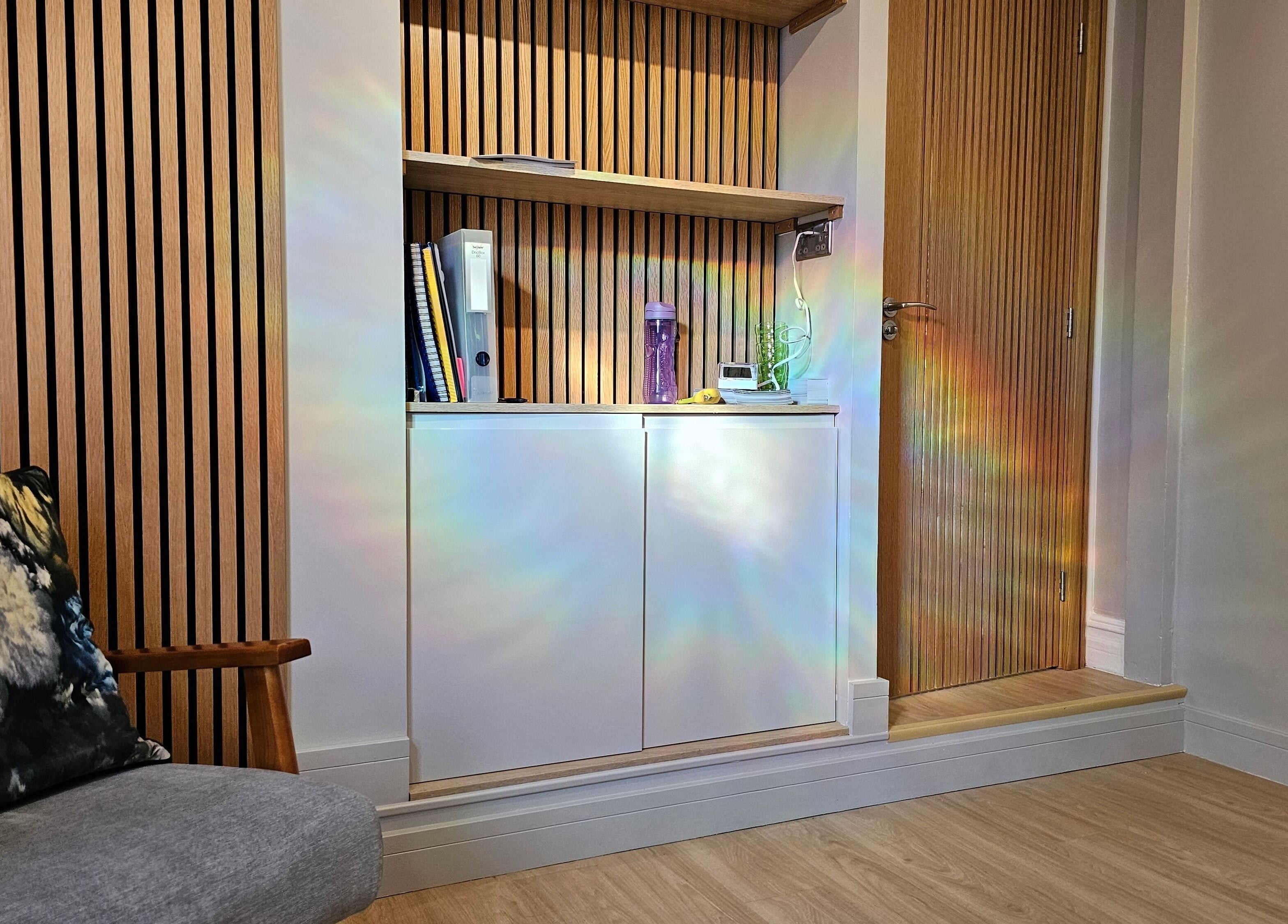 Modern wooden-slatted wall with a cozy chair at Equilize Holistic Therapies, Wadhurst, England, GB.