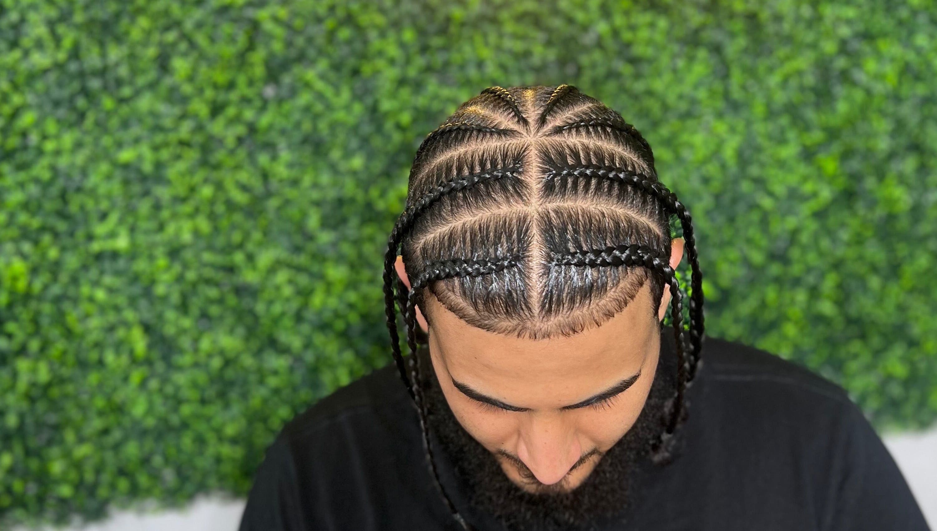 Intricate braids at Goldy Mane Collection in Miami, Florida, US, showcasing expert styling in a lush setting.