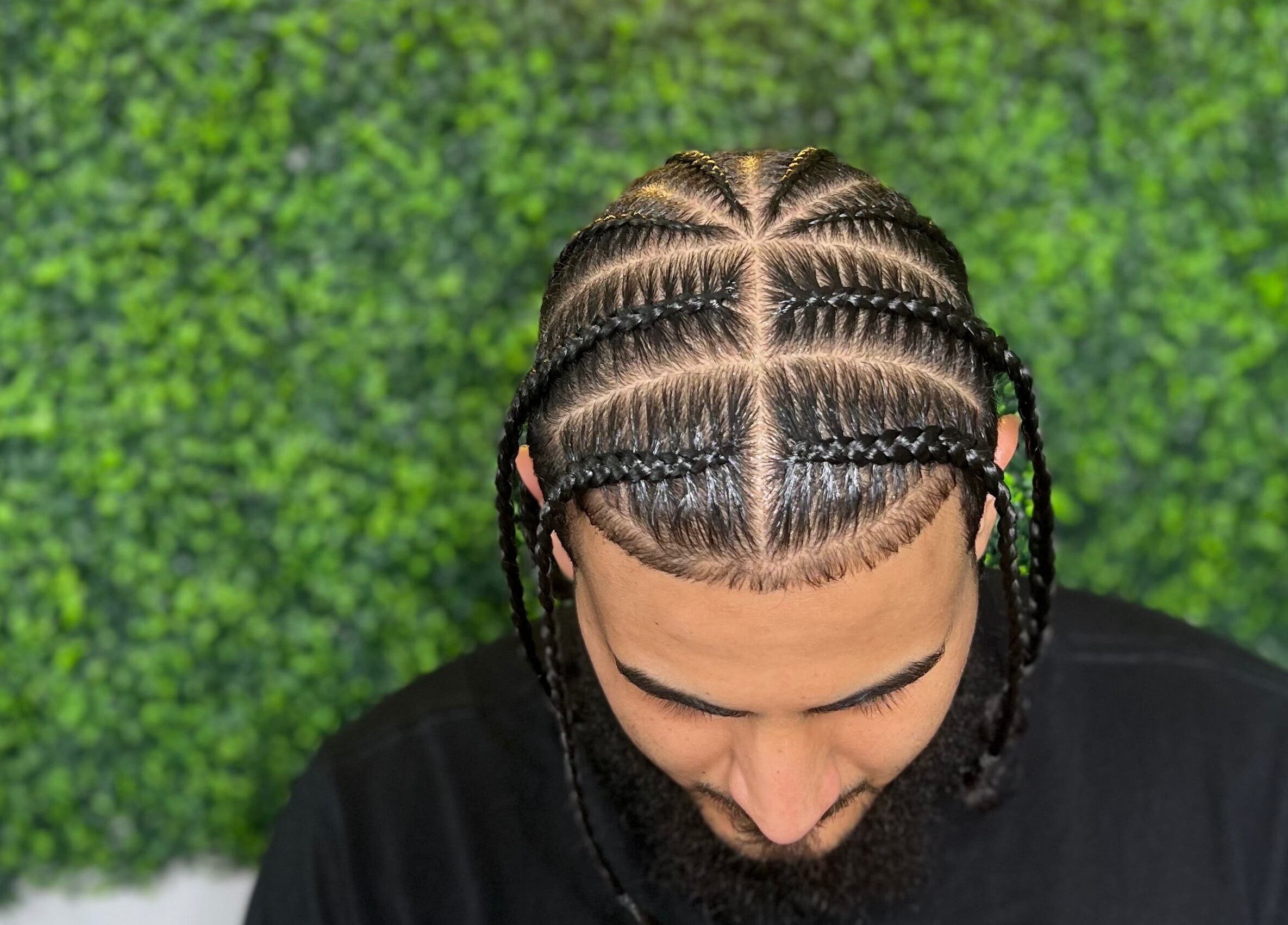 Intricate braids at Goldy Mane Collection in Miami, Florida, US, showcasing expert styling in a lush setting.