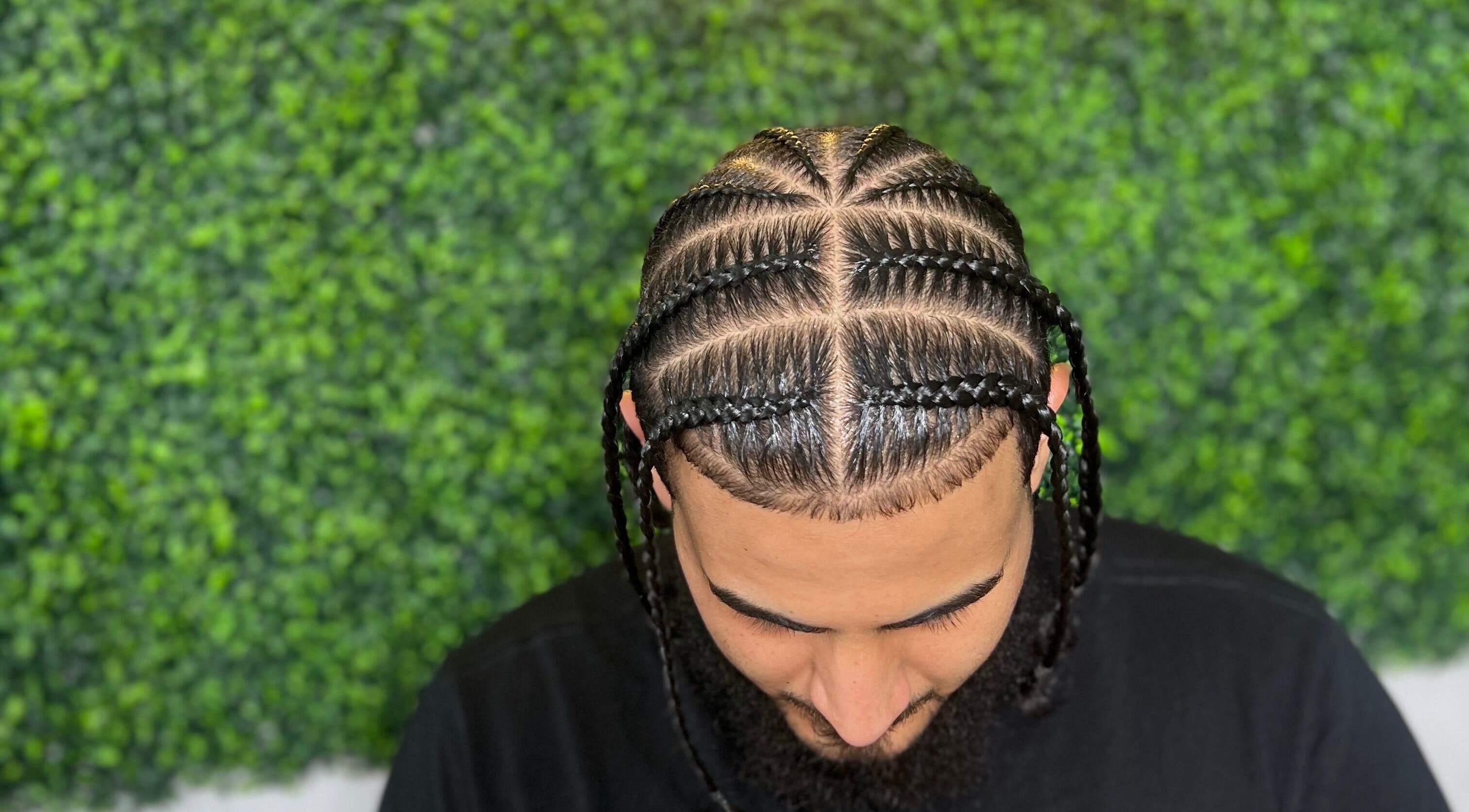 Intricate braids at Goldy Mane Collection in Miami, Florida, US, showcasing expert styling in a lush setting.