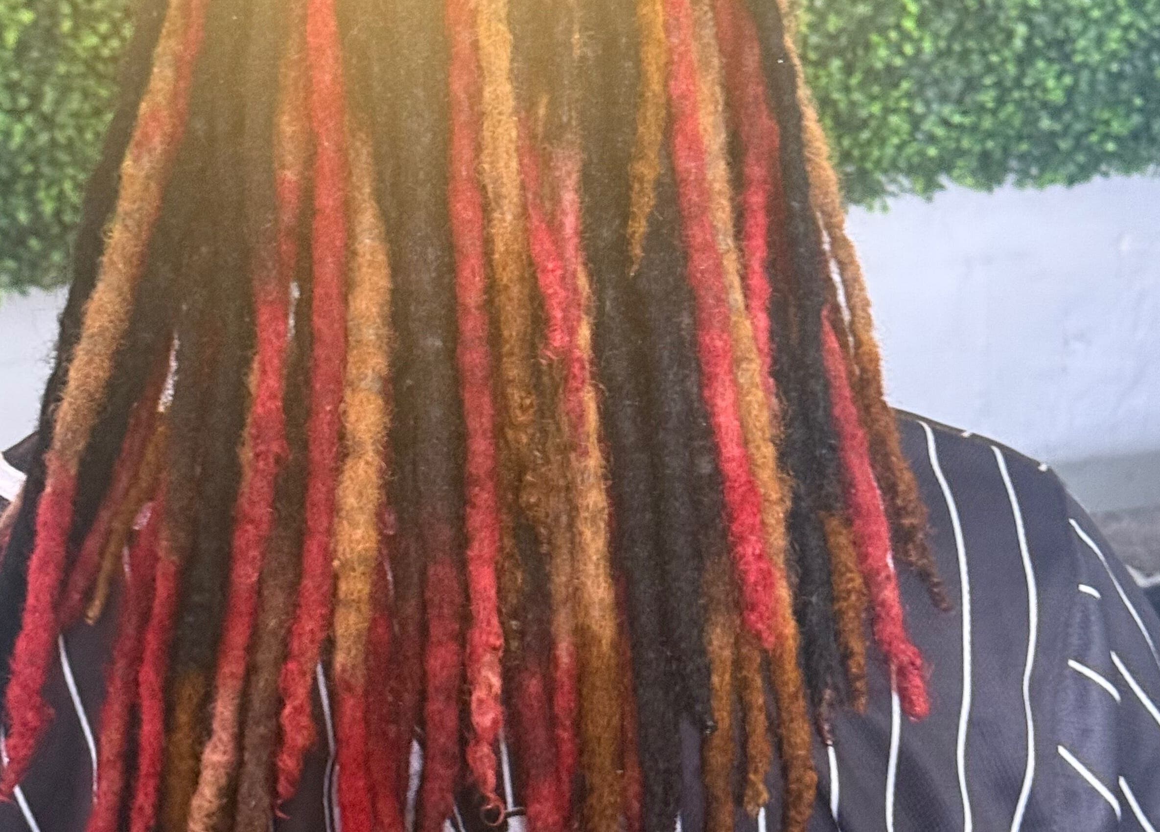 Vibrant multi-colored dreadlocks styled at Goldy Mane Collection in Miami, Florida, US.