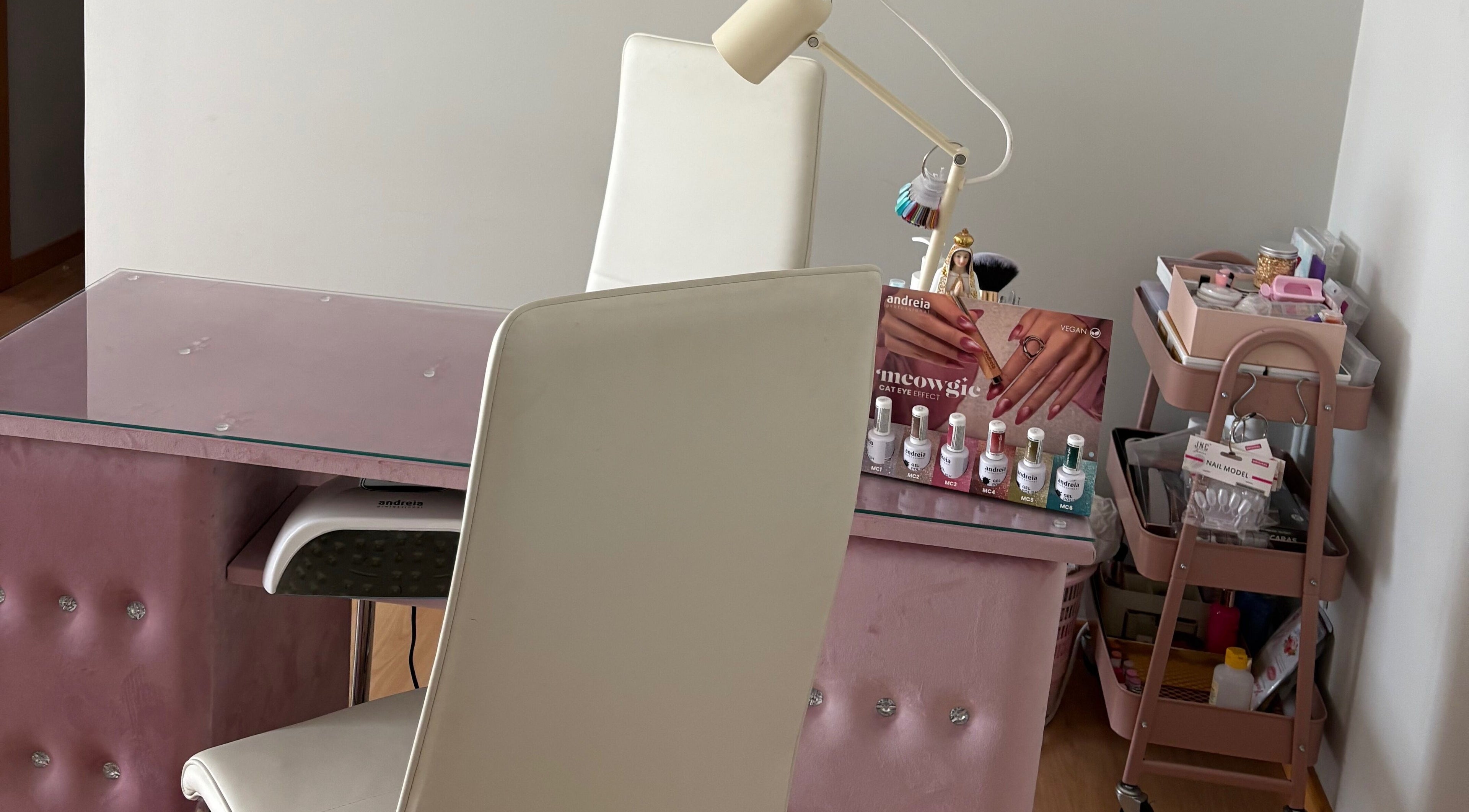 Mesa de manicure em Deusas Divinas, Maia, Porto, PT, equipada com esmaltes e luminária moderna.