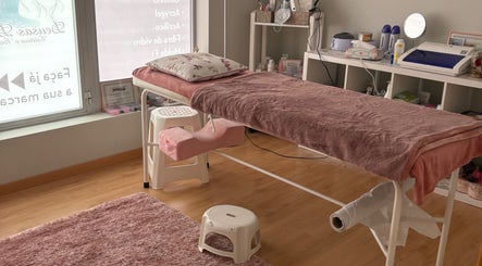 Sala de estética em Deusas Divinas, Maia, Porto, PT. Mesa de tratamentos com toalha rosa e decoração relaxante.