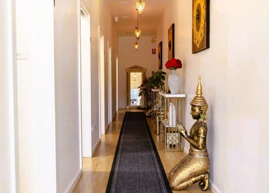 Elegant corridor at Cheewa Aroma Remedial Thai in Melbourne, Victoria, AU featuring statues and ambient lighting.