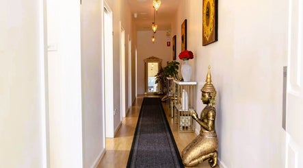 Elegant corridor at Cheewa Aroma Remedial Thai in Melbourne, Victoria, AU featuring statues and ambient lighting.
