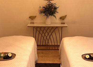 Relaxing therapy beds at Cheewa Aroma Remedial Thai, Melbourne, Victoria, AU, adorned with candles and flowers.