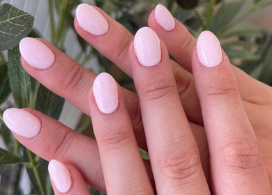 Elegant pink manicure at The NailpodTw in Royal Tunbridge Wells, England, GB with lush plant background.