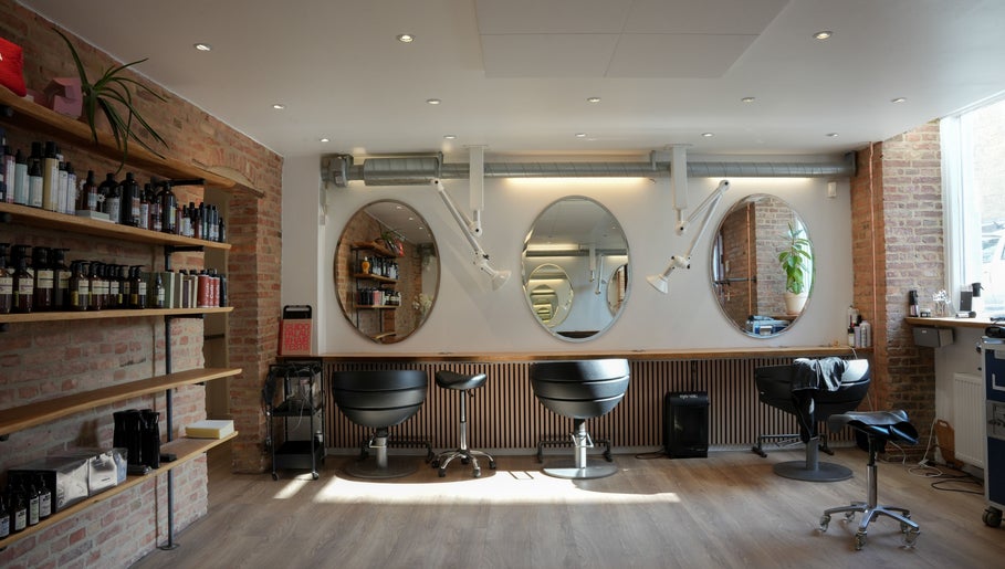 Inside view of Hair By Penny Kotsi salon in København, Denmark, DK showcasing stylish chairs and mirrors.