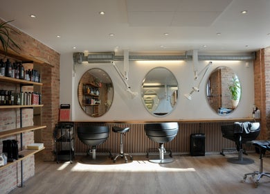 Inside view of Hair By Penny Kotsi salon in København, Denmark, DK showcasing stylish chairs and mirrors.