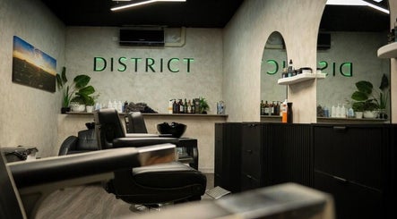 Modern interior of District Barber Studio in Samford Village, Queensland, AU showcasing sleek styling chairs and decor.