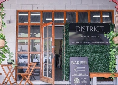 District Barber Studio entrance with greenery in Samford Village, Queensland, AU.