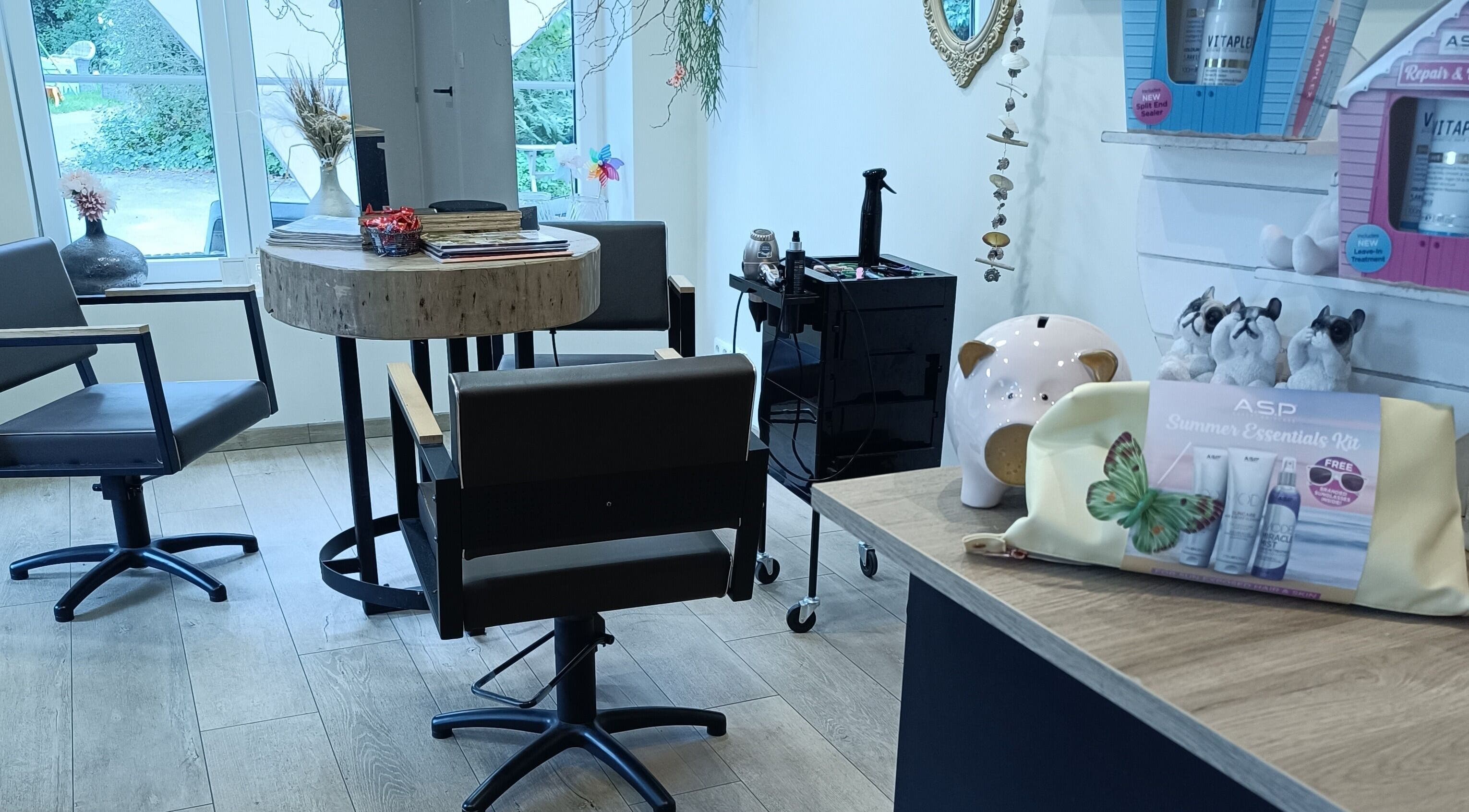 Moderne saloninterieur bij Haar&Zo Brugge, Brugge, Vlaams Gewest, BE met stoelen en verzorgingsproducten.