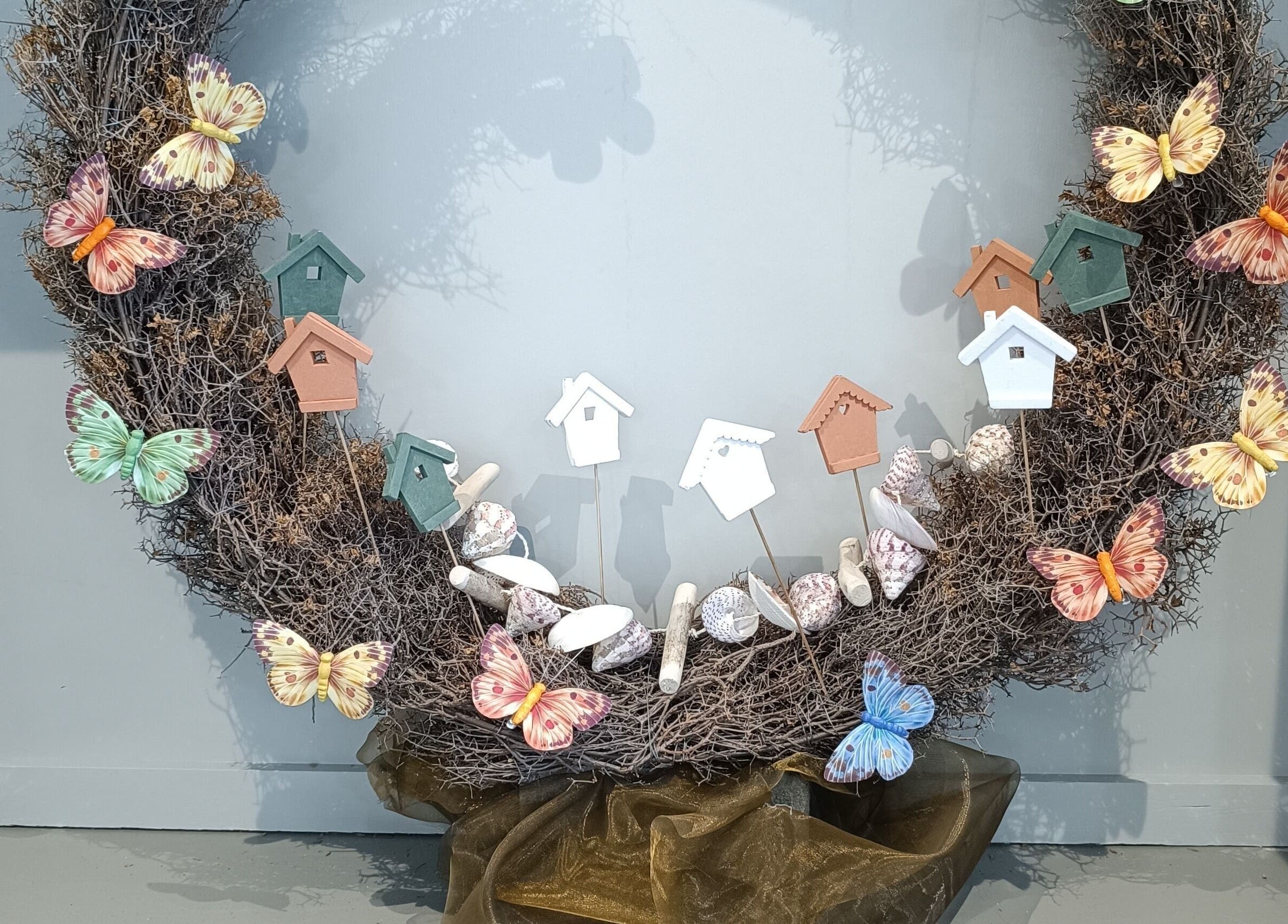 Decoratieve krans met kleurrijke vlinders en vogelhuisjes bij Haar&Zo Brugge, Brugge, Vlaams Gewest, BE.