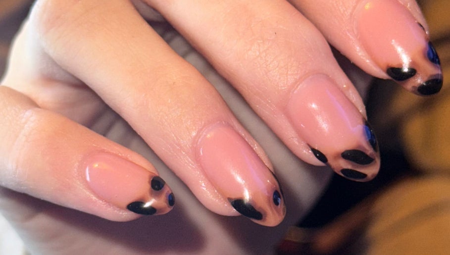 Close-up of elegant nail art at The Beauty Room, Seaford, England, GB showcasing black and nude polish.