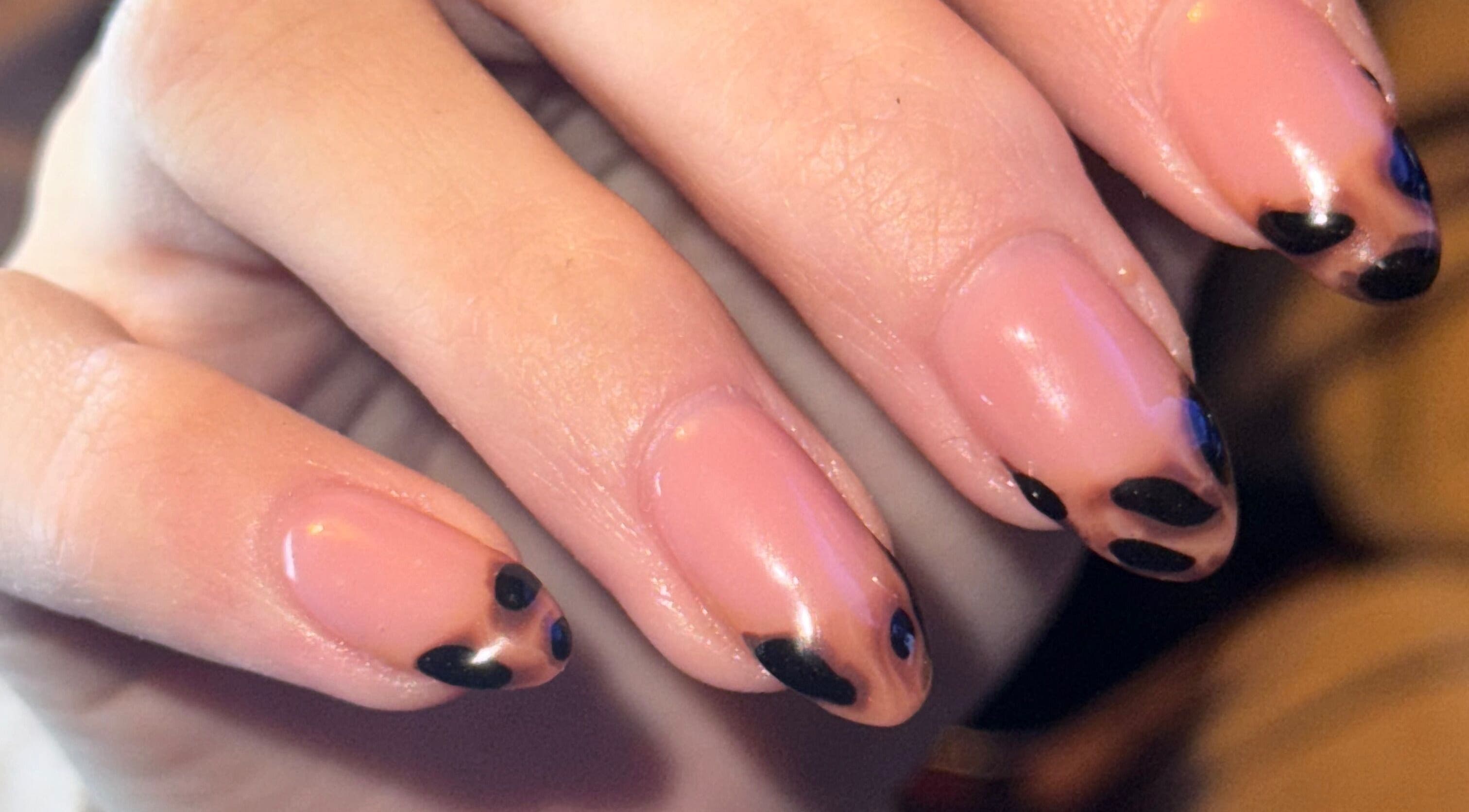 Close-up of elegant nail art at The Beauty Room, Seaford, England, GB showcasing black and nude polish.