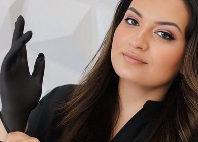Professional at AvaBellas Brow & Skincare Studio in Bonney Lake, Washington, US, prepares with black gloves.