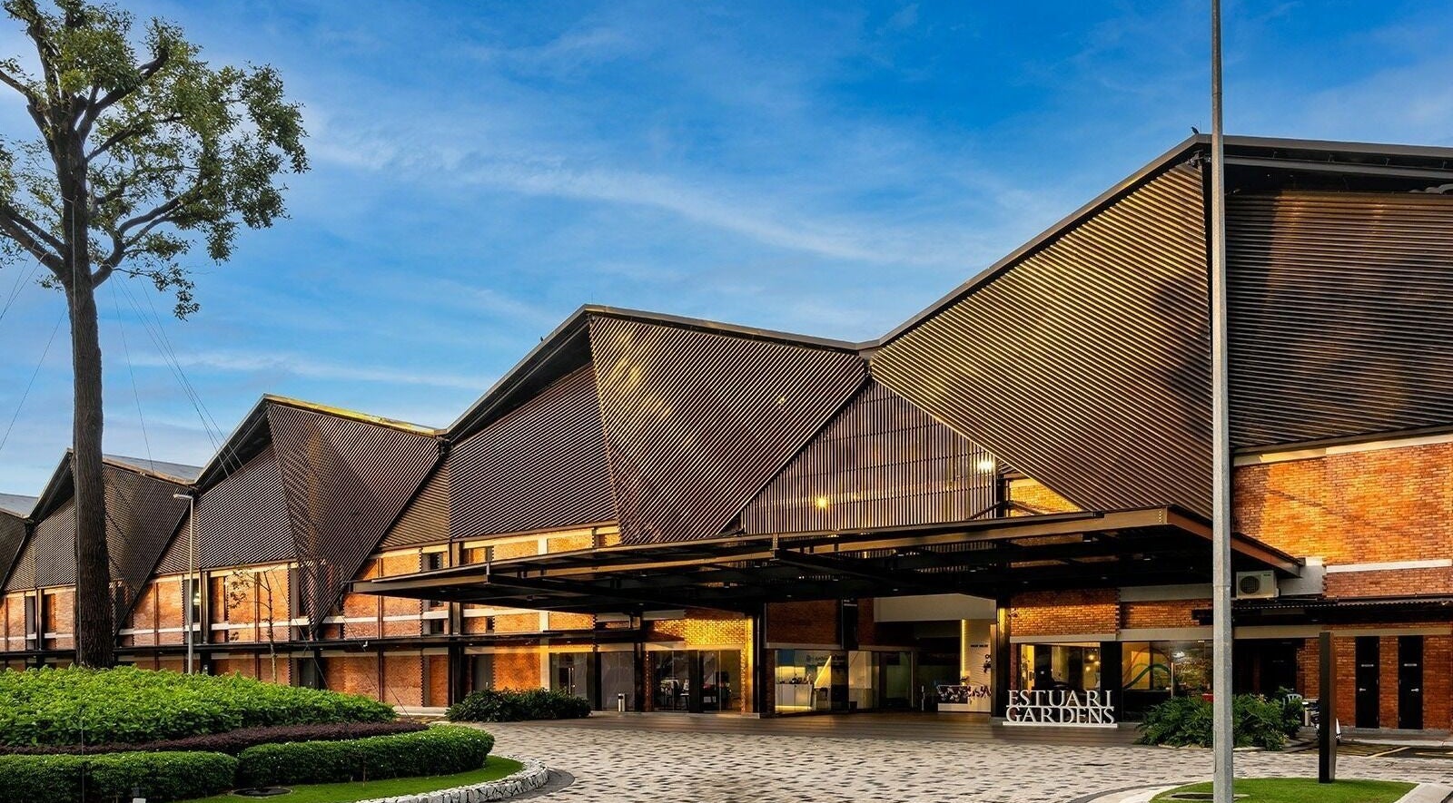 Modern exterior of Estuari Sports Complex in Iskandar Puteri, Johor, MY under a clear blue sky.