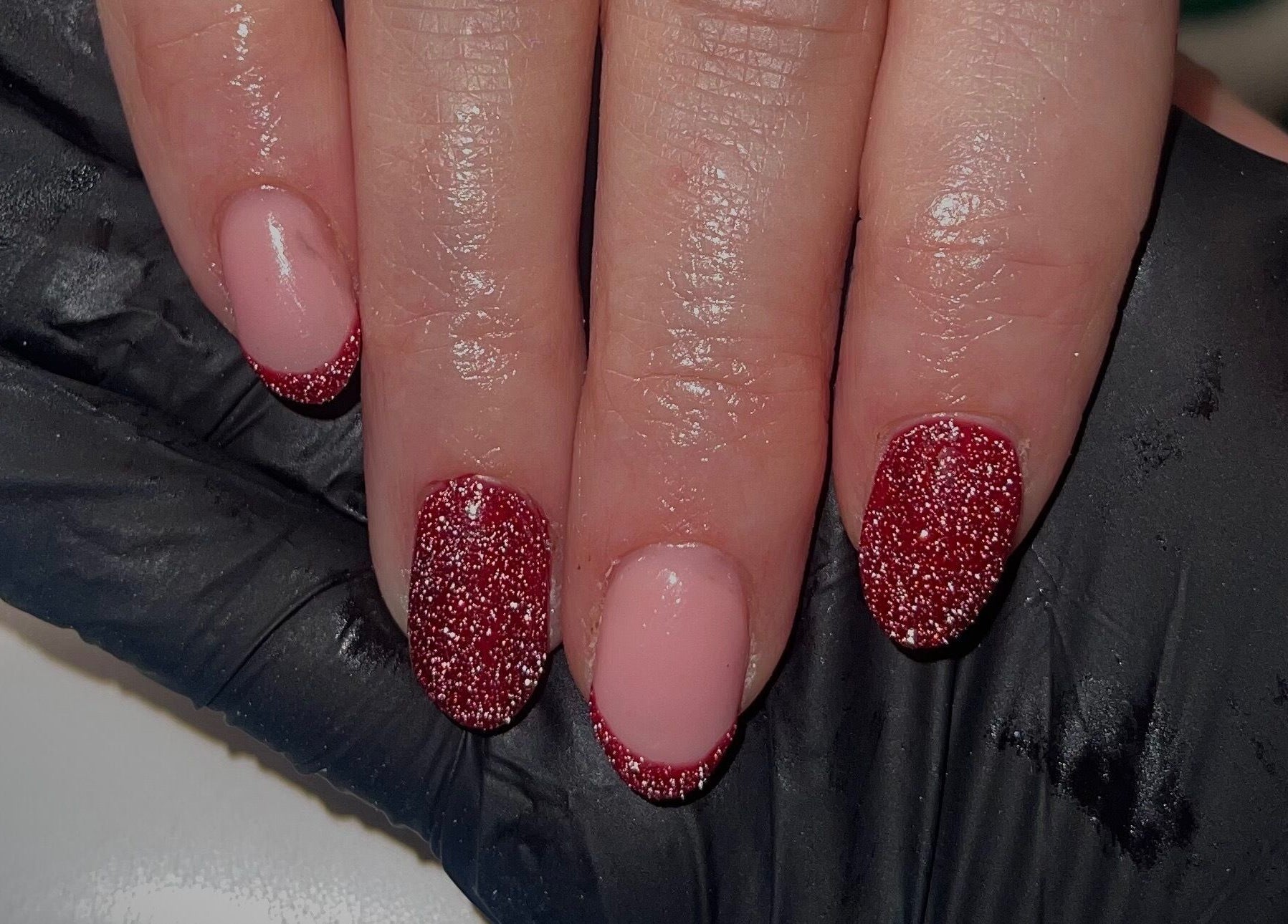 Red glitter nails at Beauty By Neve in Dalton-in-Furness, England, GB. Sparkling manicure finishes.