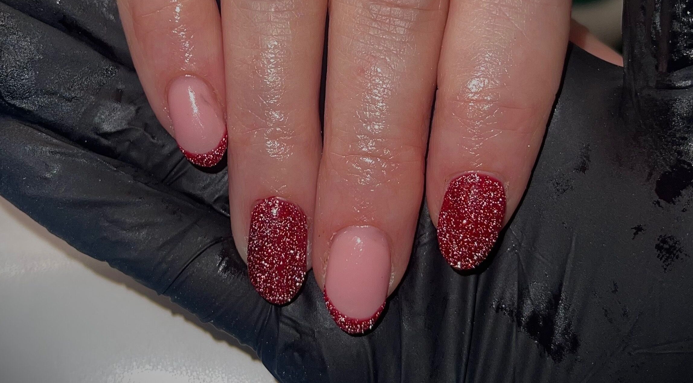 Red glitter nails at Beauty By Neve in Dalton-in-Furness, England, GB. Sparkling manicure finishes.