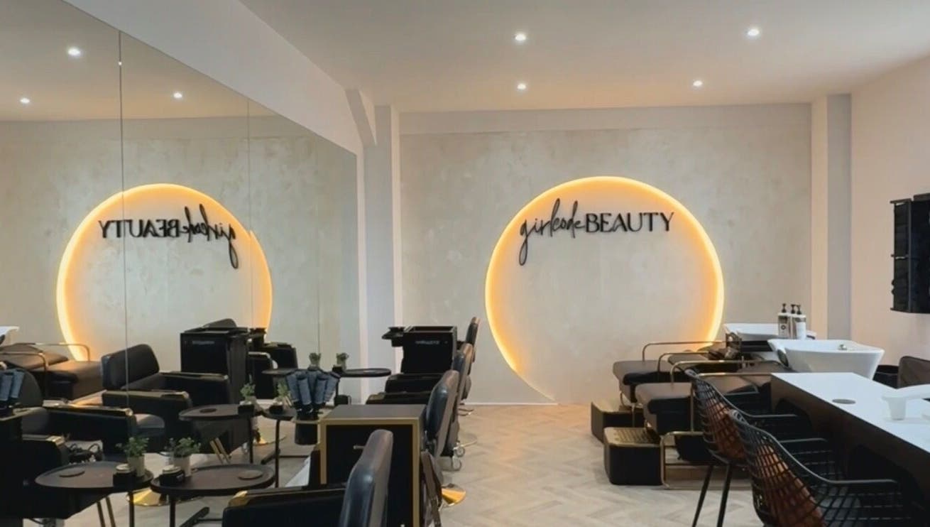 Interior of Girlcode Beauty Studio in Wirral, England, GB, showcasing modern chairs and a glowing wall decor.