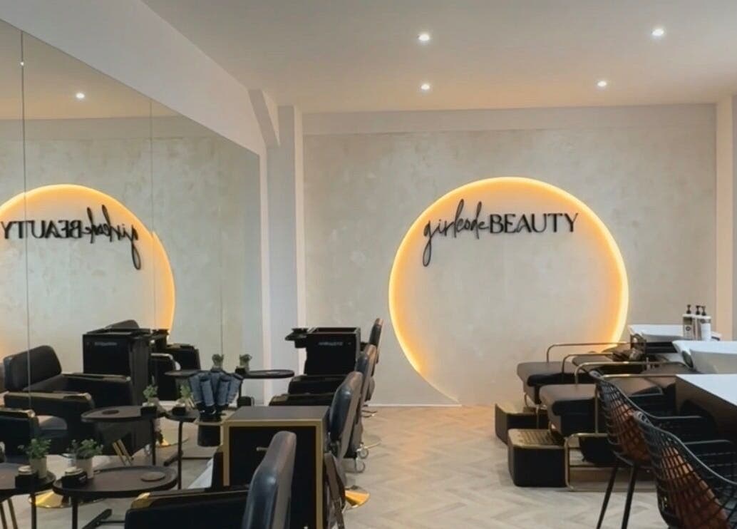 Interior of Girlcode Beauty Studio in Wirral, England, GB, showcasing modern chairs and a glowing wall decor.