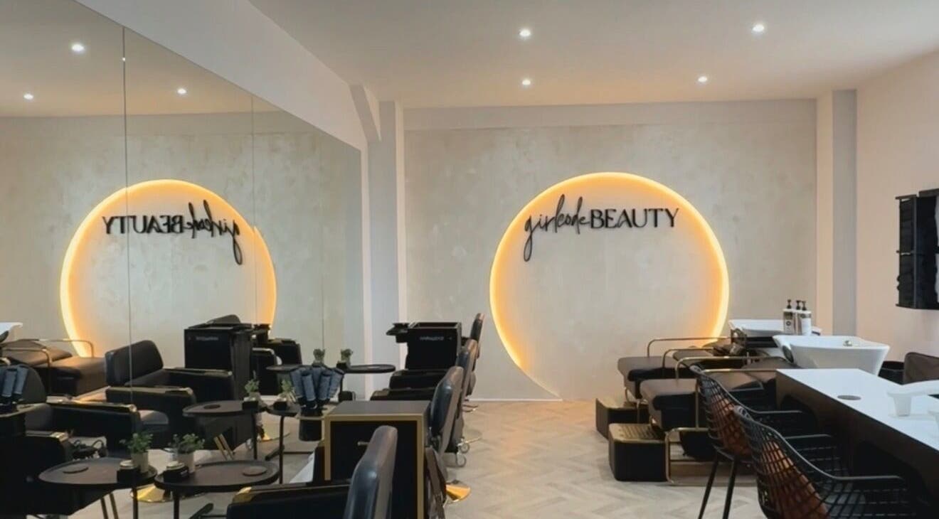 Interior of Girlcode Beauty Studio in Wirral, England, GB, showcasing modern chairs and a glowing wall decor.