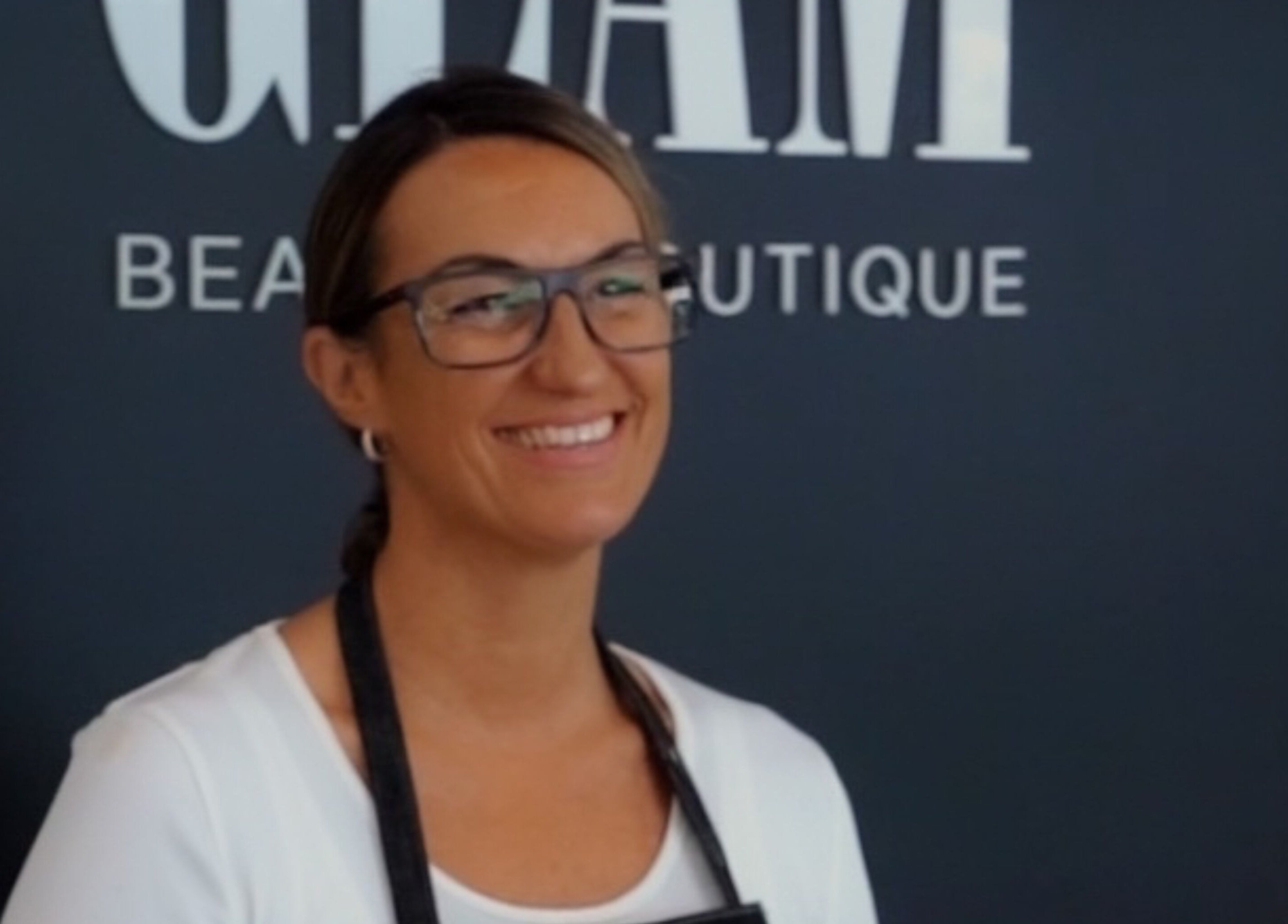 Friendly staff member at Gloglam, Main Beach, Queensland, AU, welcoming guests with a warm smile.