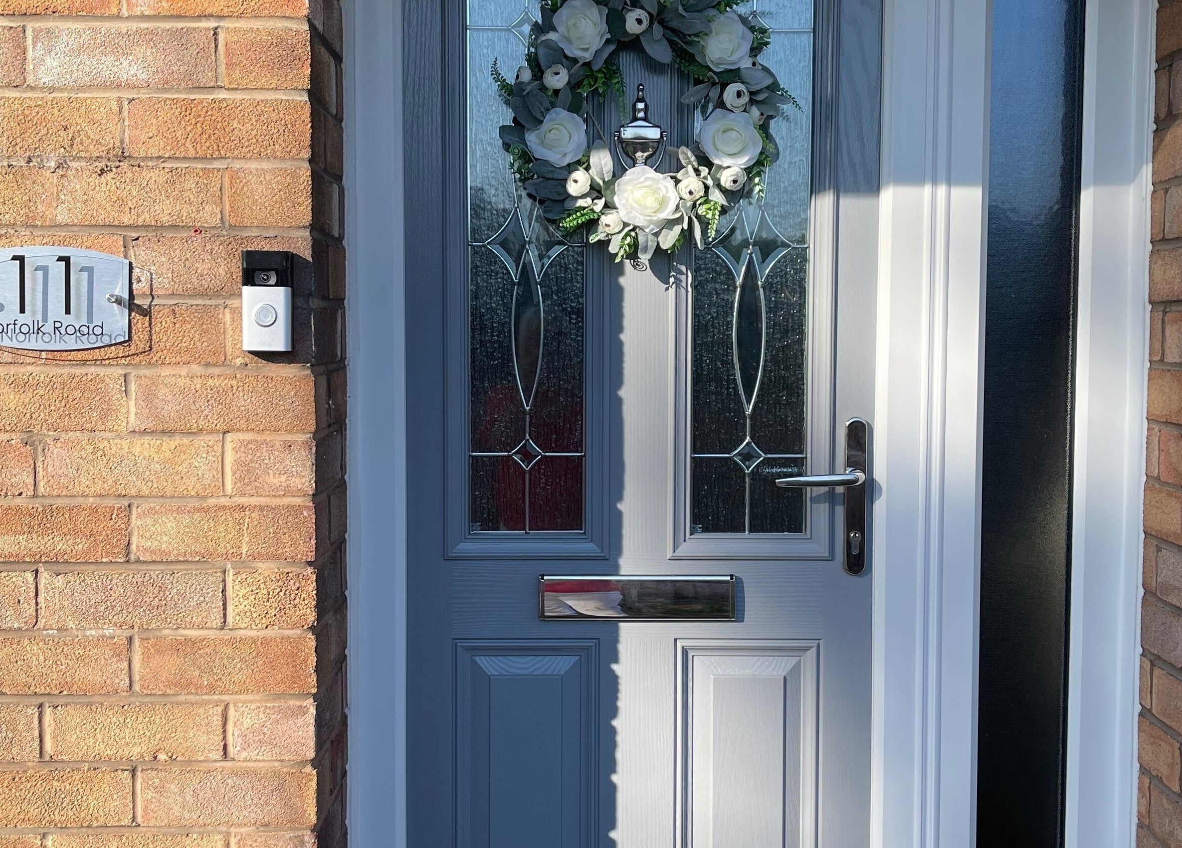 Elegant front door of Fabulash Brow and Aesthetics in Wrexham, Wales, GB, adorned with a floral wreath.