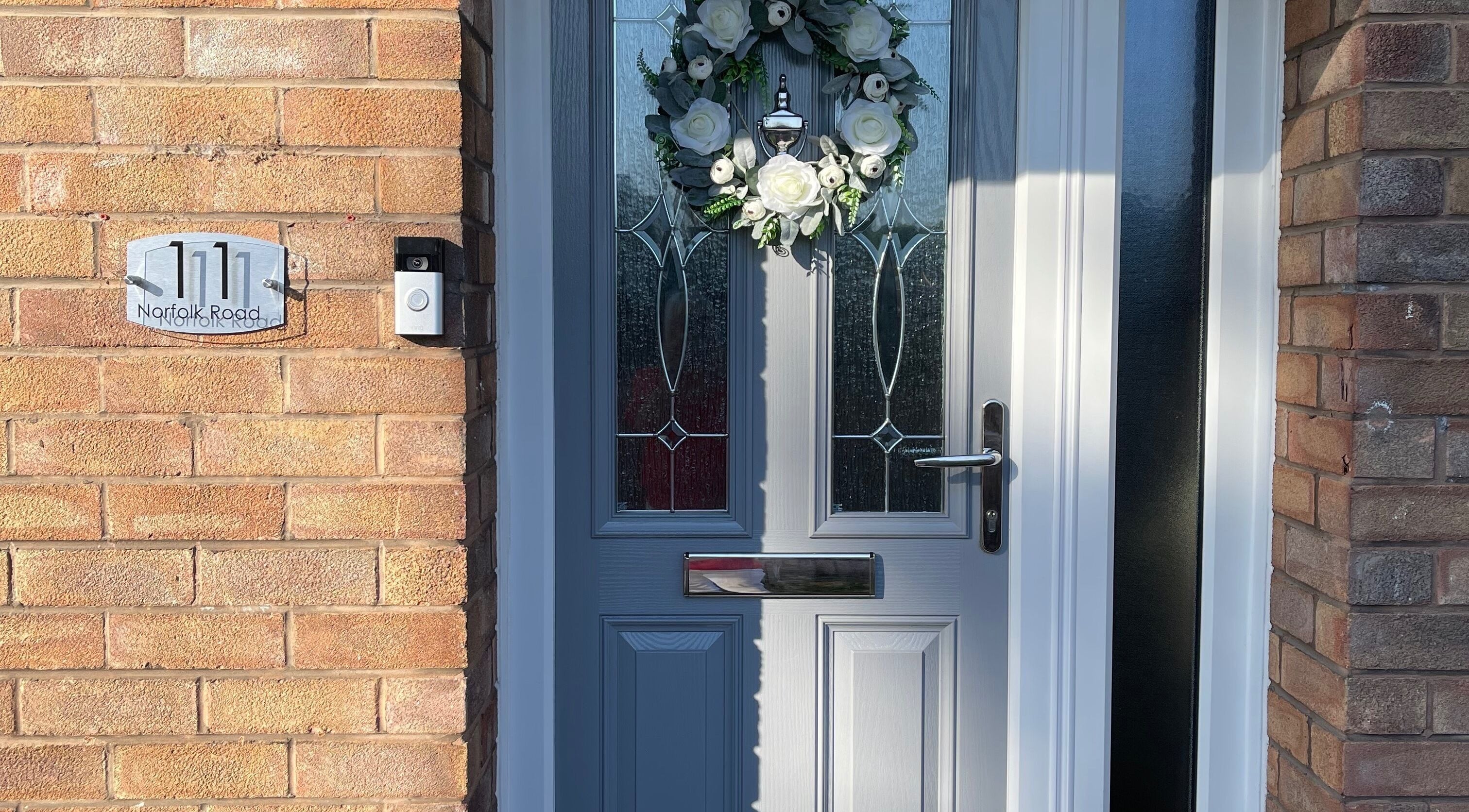 Elegant front door of Fabulash Brow and Aesthetics in Wrexham, Wales, GB, adorned with a floral wreath.