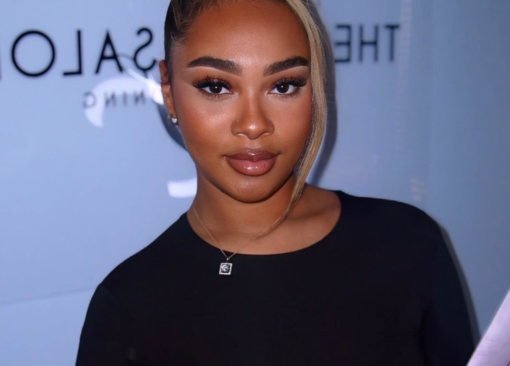 Smiling woman at Aaliyahlashh in Crawley, England, GB, holding a document.