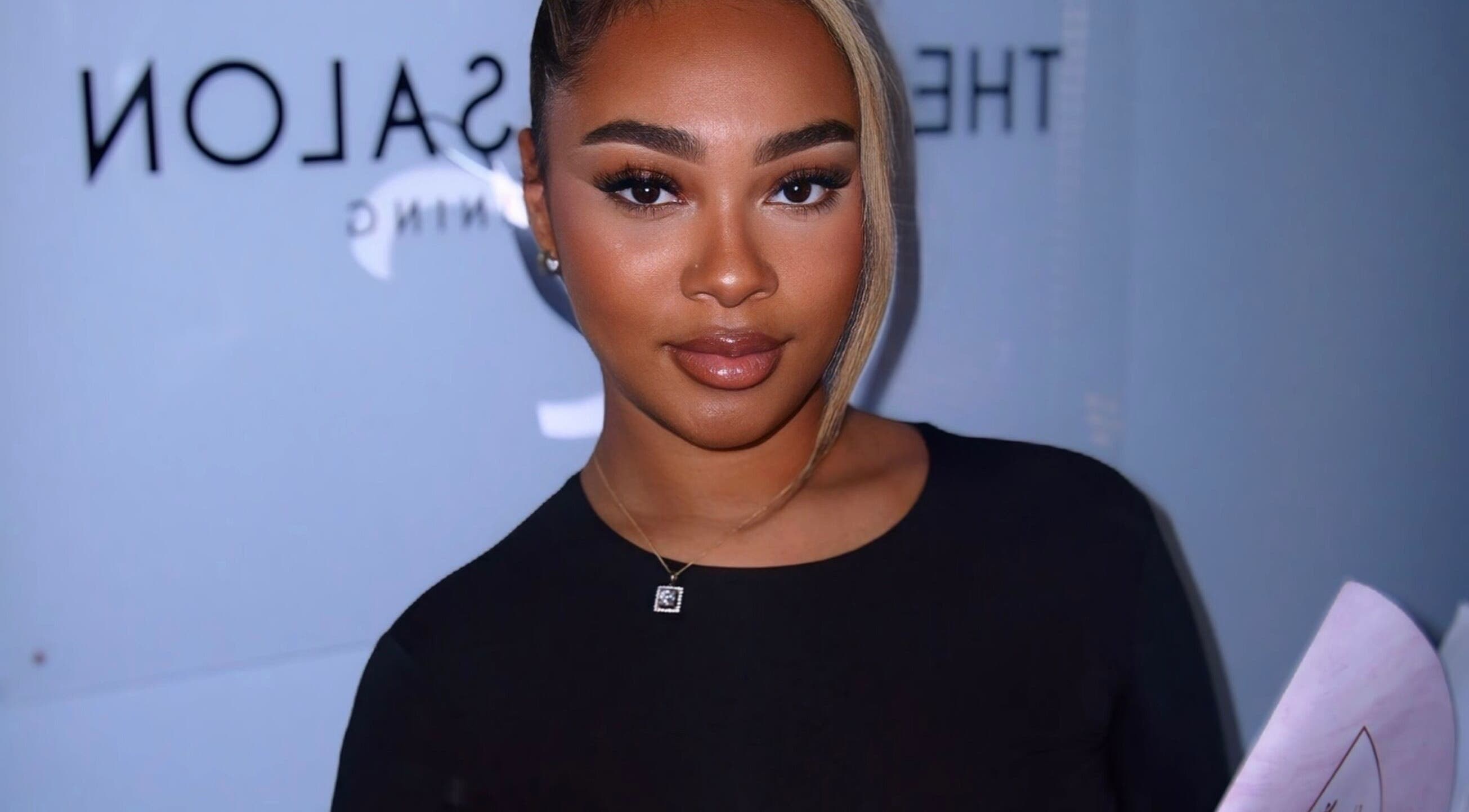 Smiling woman at Aaliyahlashh in Crawley, England, GB, holding a document.