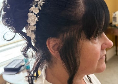 Elegant bridal updo with floral accessories at Hair & Aesthetics By Ryan, Wyboston, England, GB.