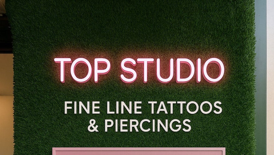Neon sign of Top Studio Tattoo & Piercing located in Toronto, Ontario, CA, highlighting fine line tattoos.