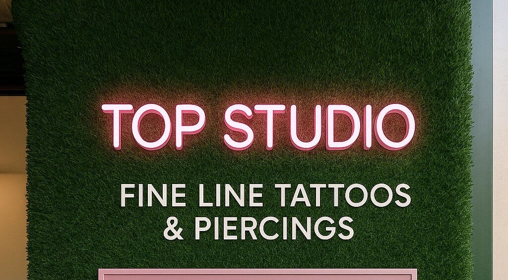 Neon sign of Top Studio Tattoo & Piercing located in Toronto, Ontario, CA, highlighting fine line tattoos.