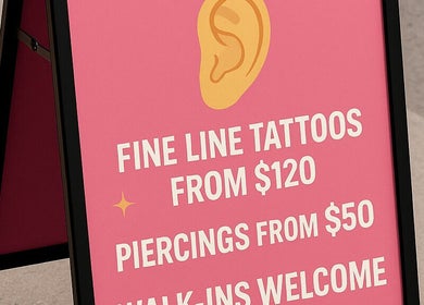 Signboard for Top Studio Tattoo & Piercing in Toronto, Ontario, CA, offering tattoos from $120 and piercings from $50.