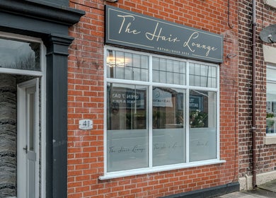 The Hair Lounge exterior in Chorley, England, GB showcasing elegant signage and brick facade.