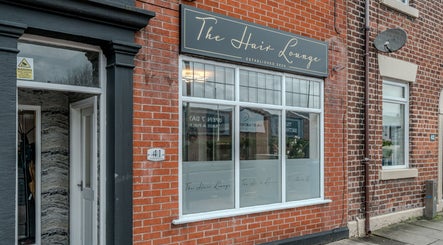 The Hair Lounge exterior in Chorley, England, GB showcasing elegant signage and brick facade.