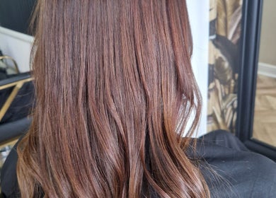 Smooth, chestnut-brown hair styled at The Hair Lounge in Chorley, England, GB near a mirror.