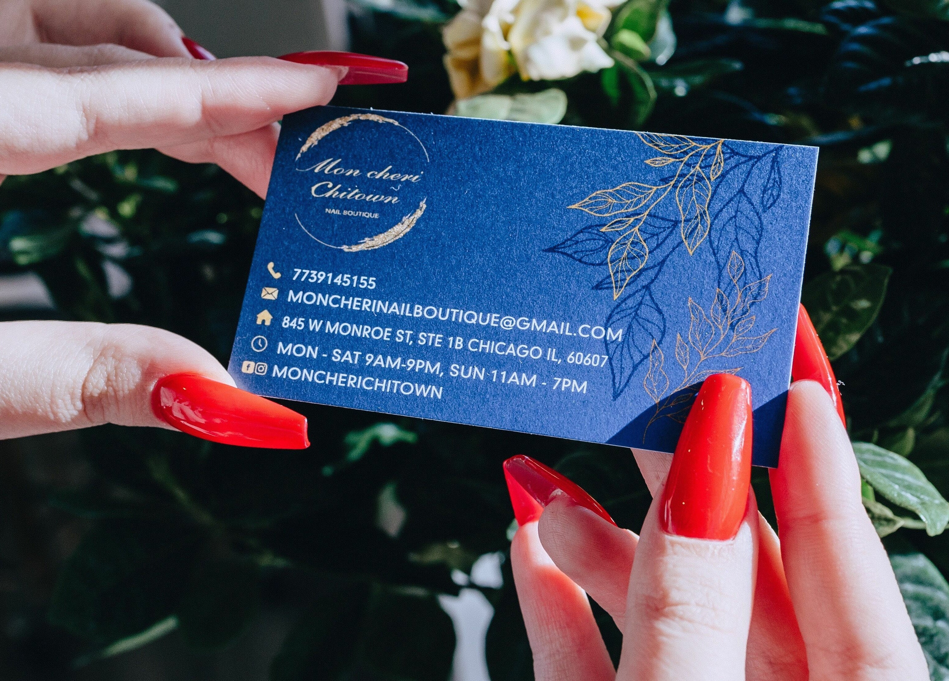 Close-up of a hand holding Mon Cheri Chitown business card in Chicago, Illinois, US.