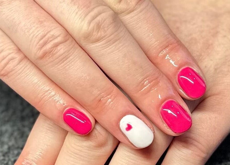 Bright pink manicure with heart accent at The Nail and Lash Lounge Perth, Perth, Scotland, GB.
