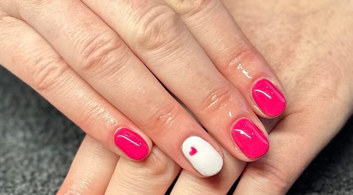 Bright pink manicure with heart accent at The Nail and Lash Lounge Perth, Perth, Scotland, GB.