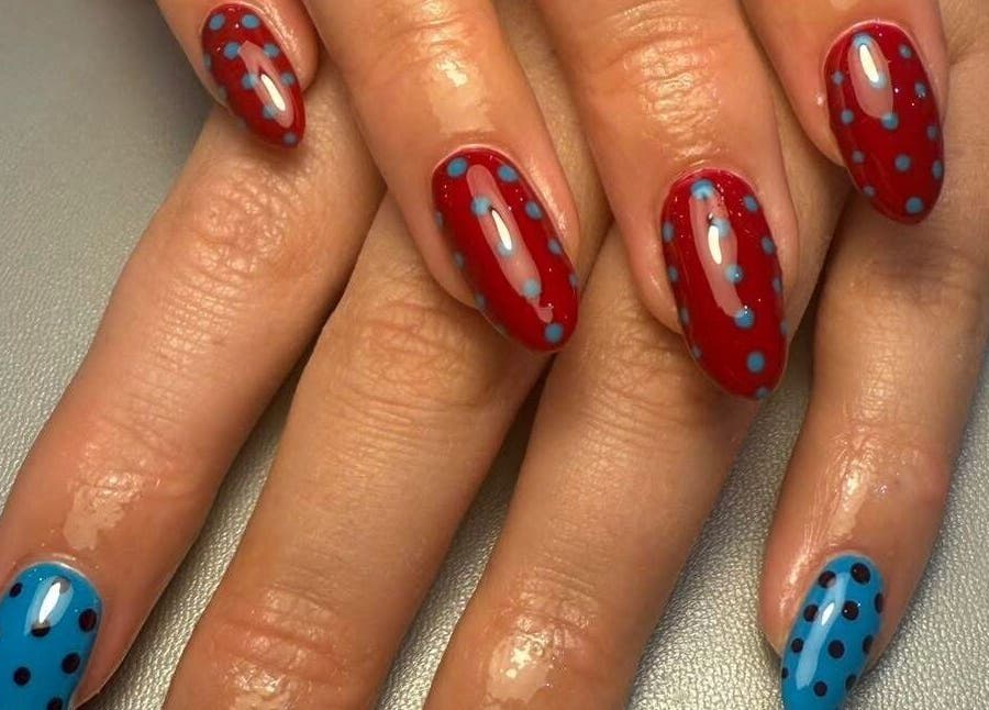 Vibrant red and blue polka dot nails at The Nail and Lash Lounge Perth, Perth, Scotland, GB.