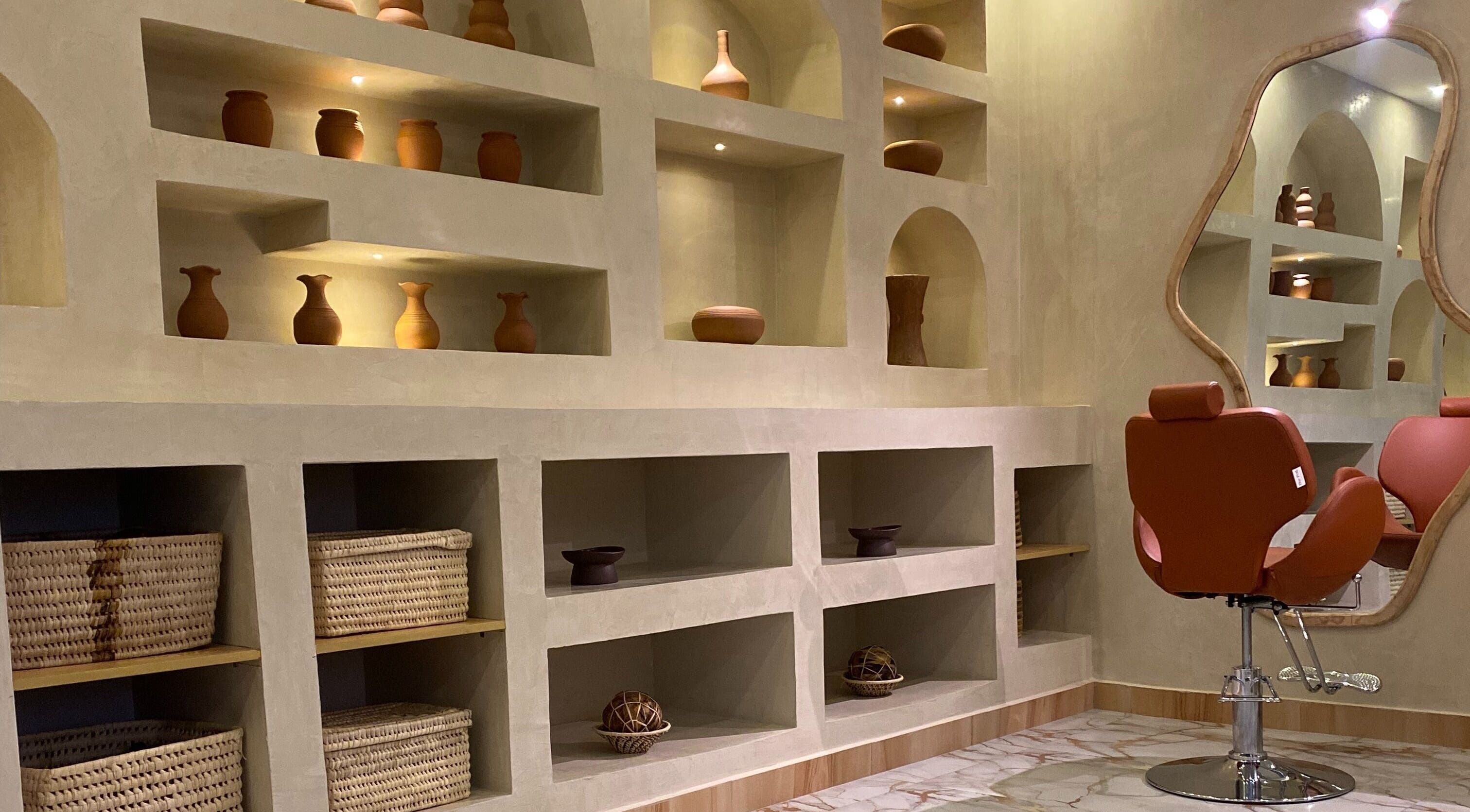 Elegant salon interior at The Pod, Kampala, Central Region, UG with pottery decor and styling chair.