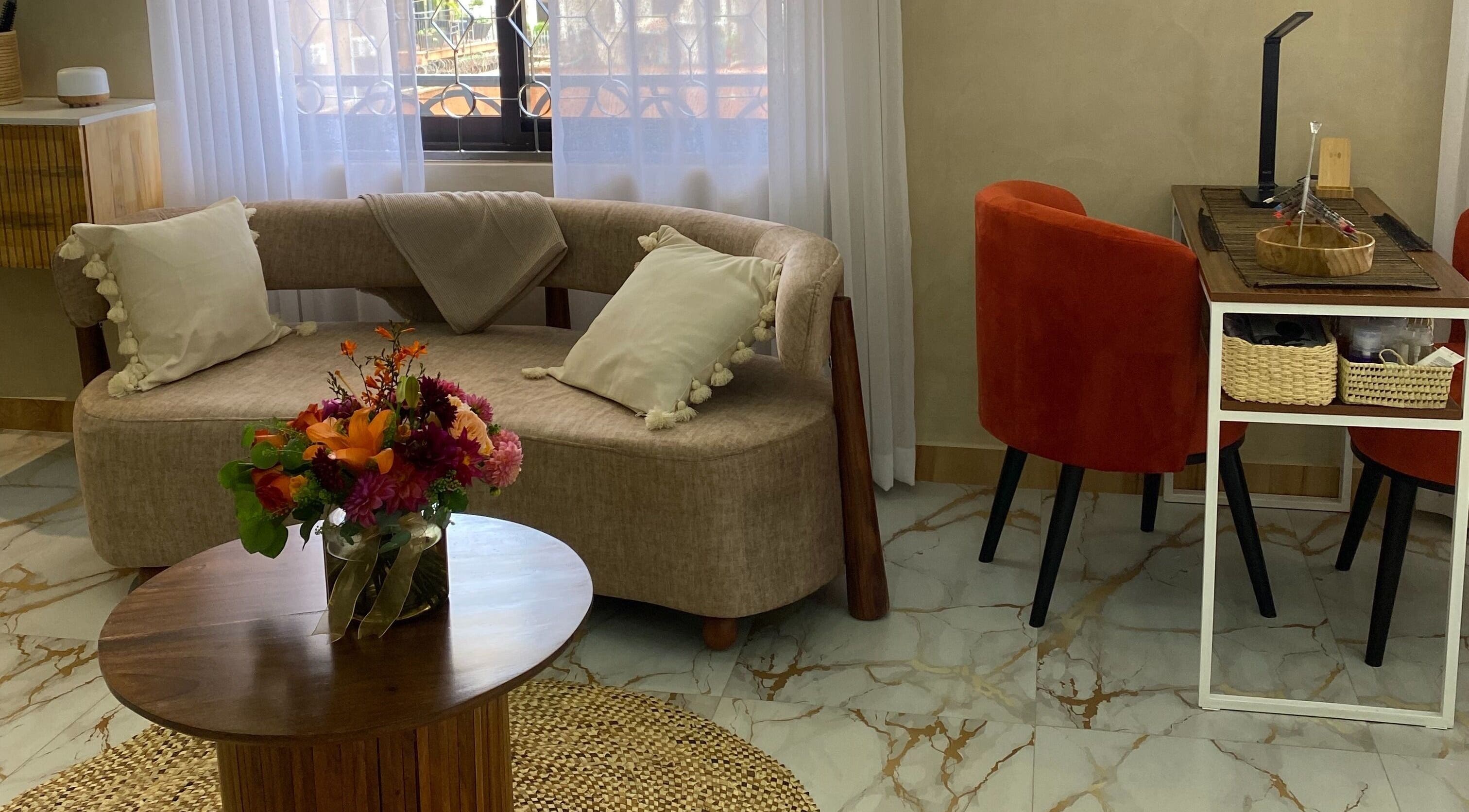 Elegant lounge at The Pod, Kampala, Central Region, UG, featuring a stylish couch and vibrant floral centerpiece.