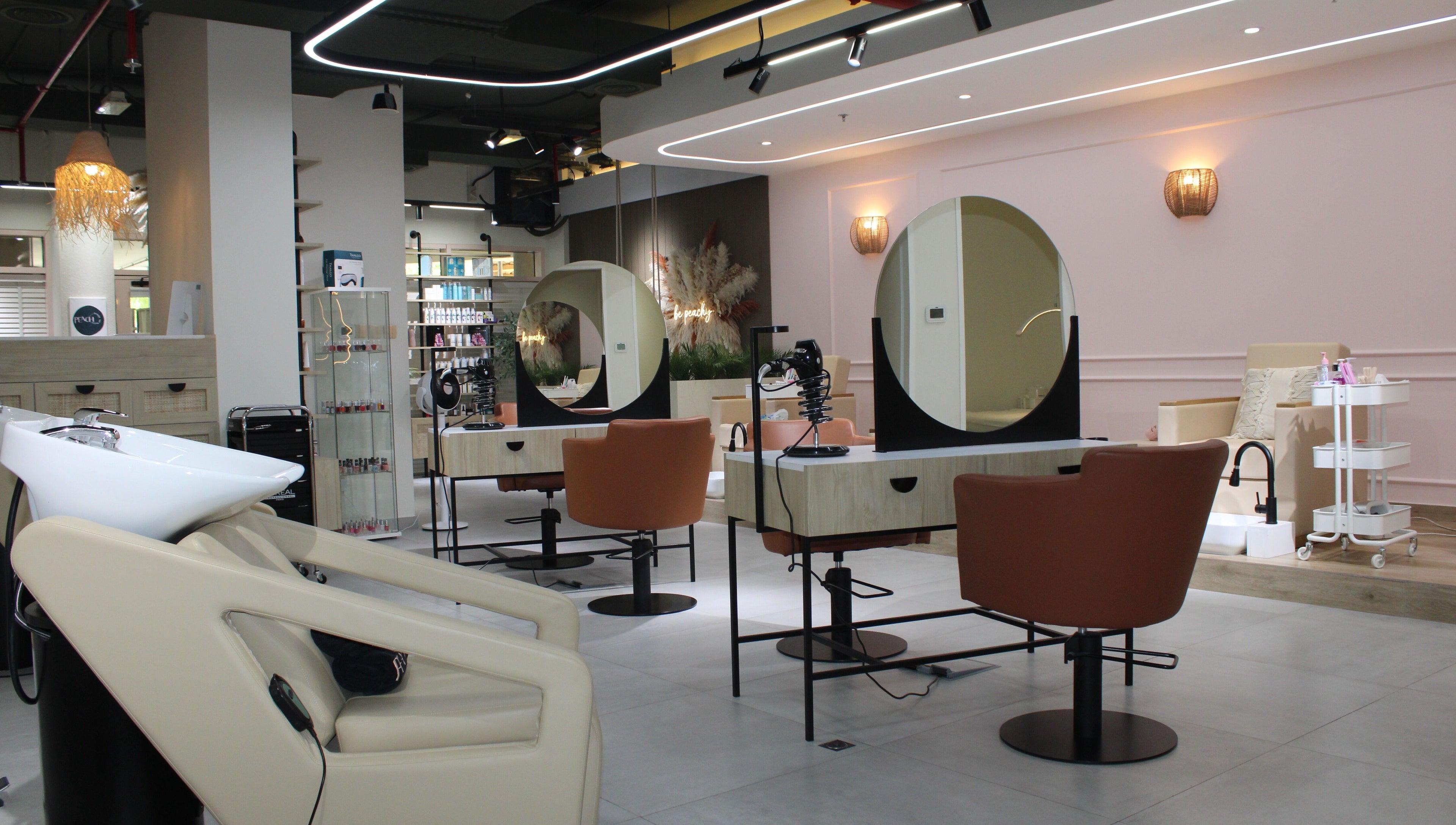 Modern interior of Peach Beauty Bar in Dubai, Dubai, AE showcasing salon chairs and elegant décor.