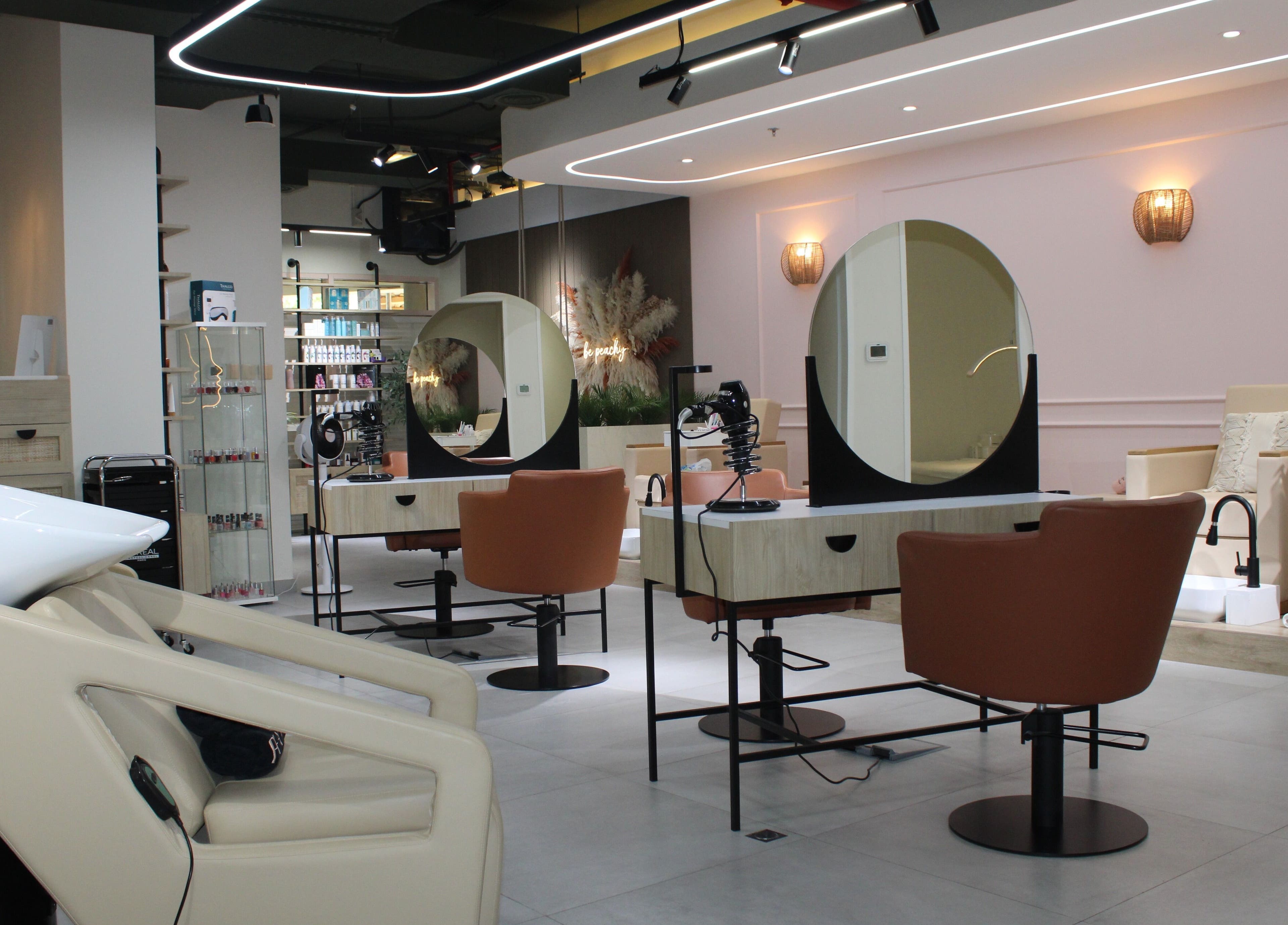 Modern interior of Peach Beauty Bar in Dubai, Dubai, AE showcasing salon chairs and elegant décor.