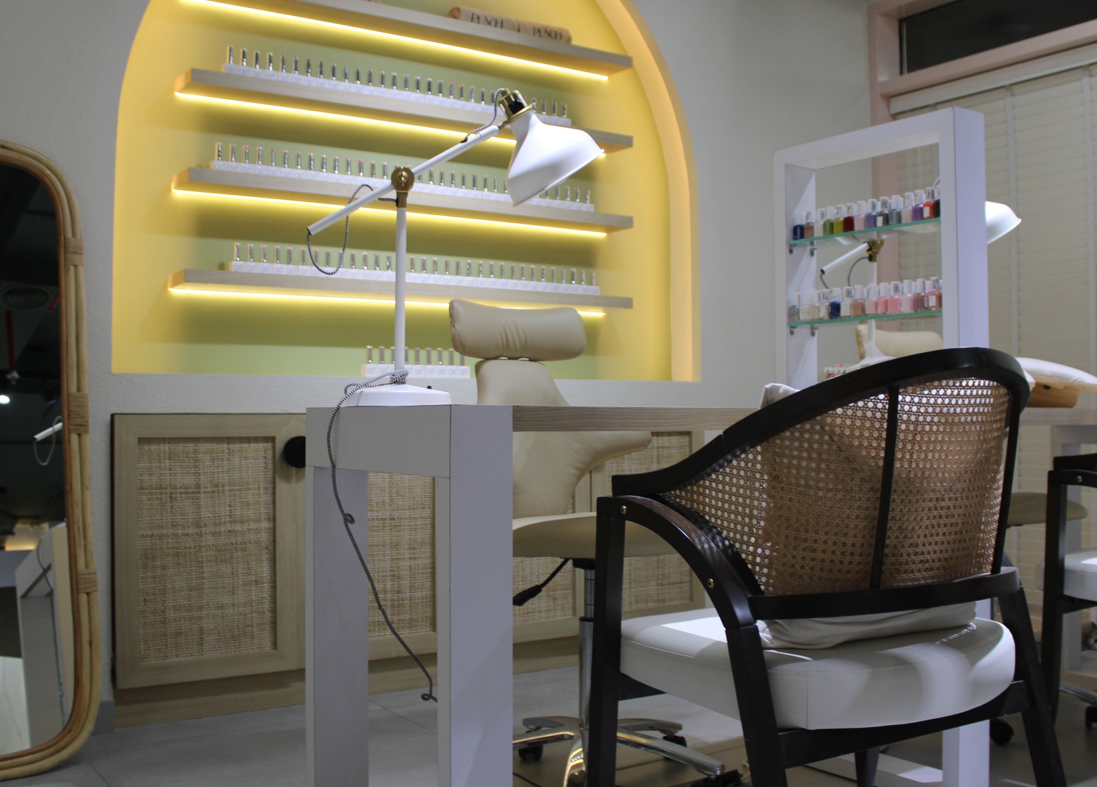 Elegant nail salon setup at Peach Beauty Bar, Dubai, Dubai, AE with stylish chairs and nail polish display.