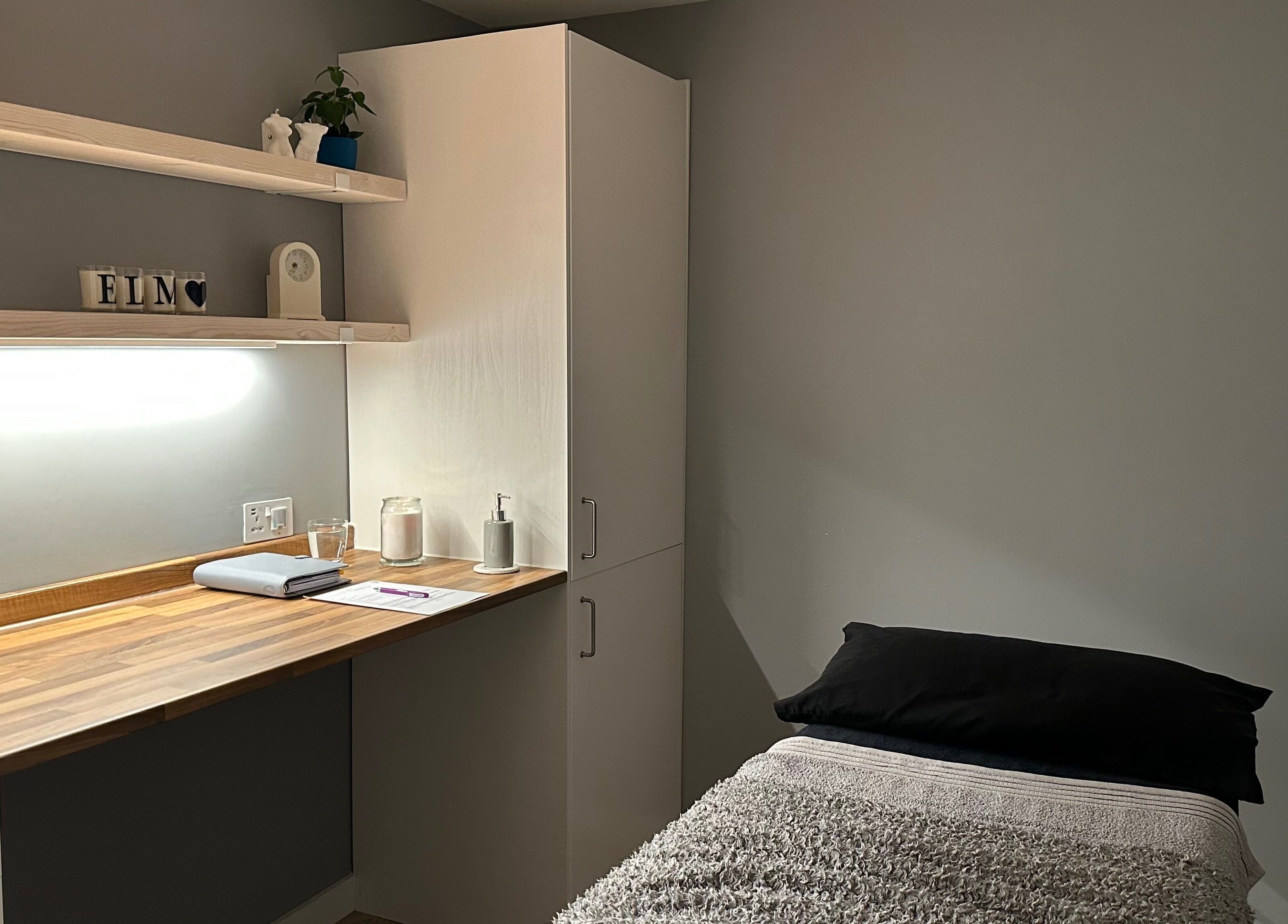 Therapy room at ELM Therapy, Buckingham, England, GB, featuring cozy bed and wooden counter for a relaxing experience.