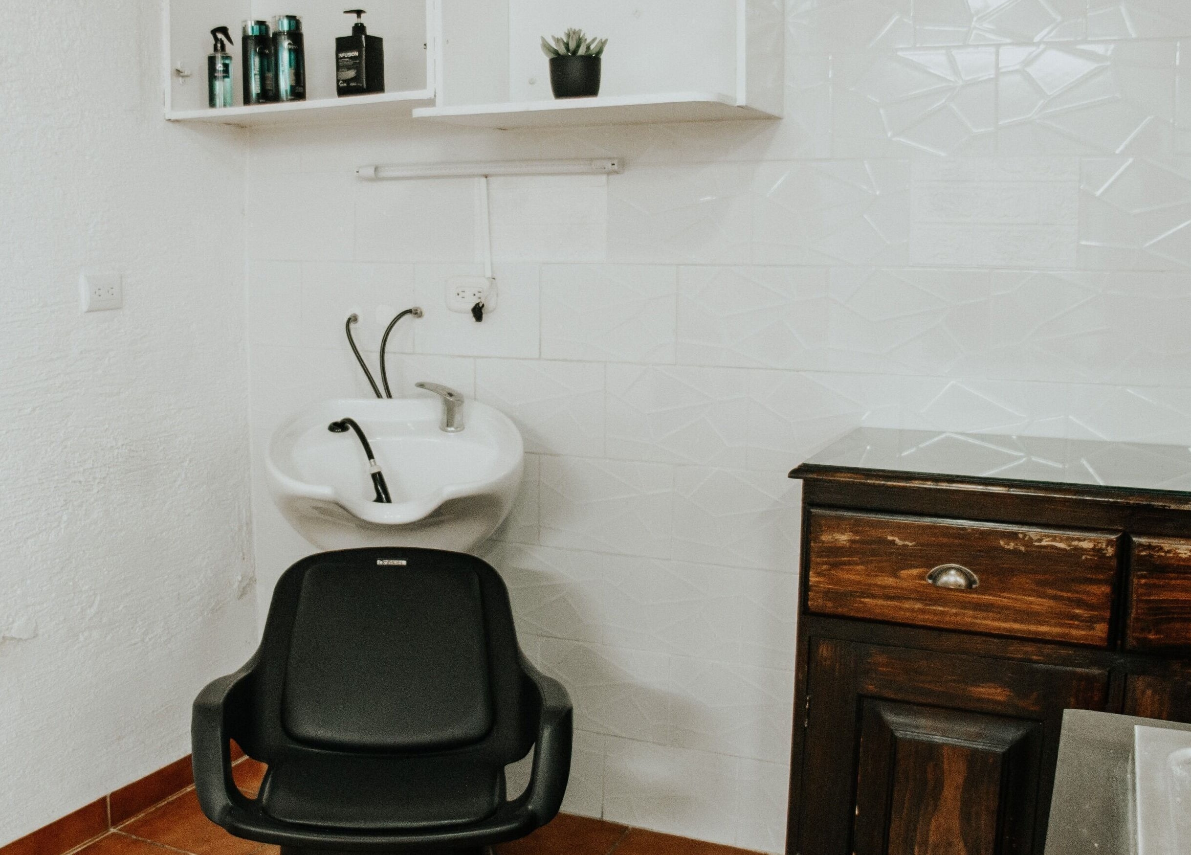 Área de lavado en Be Salón - House Hair, Antigua Guatemala, Sacatepéquez, GT, destacando un sillón moderno.