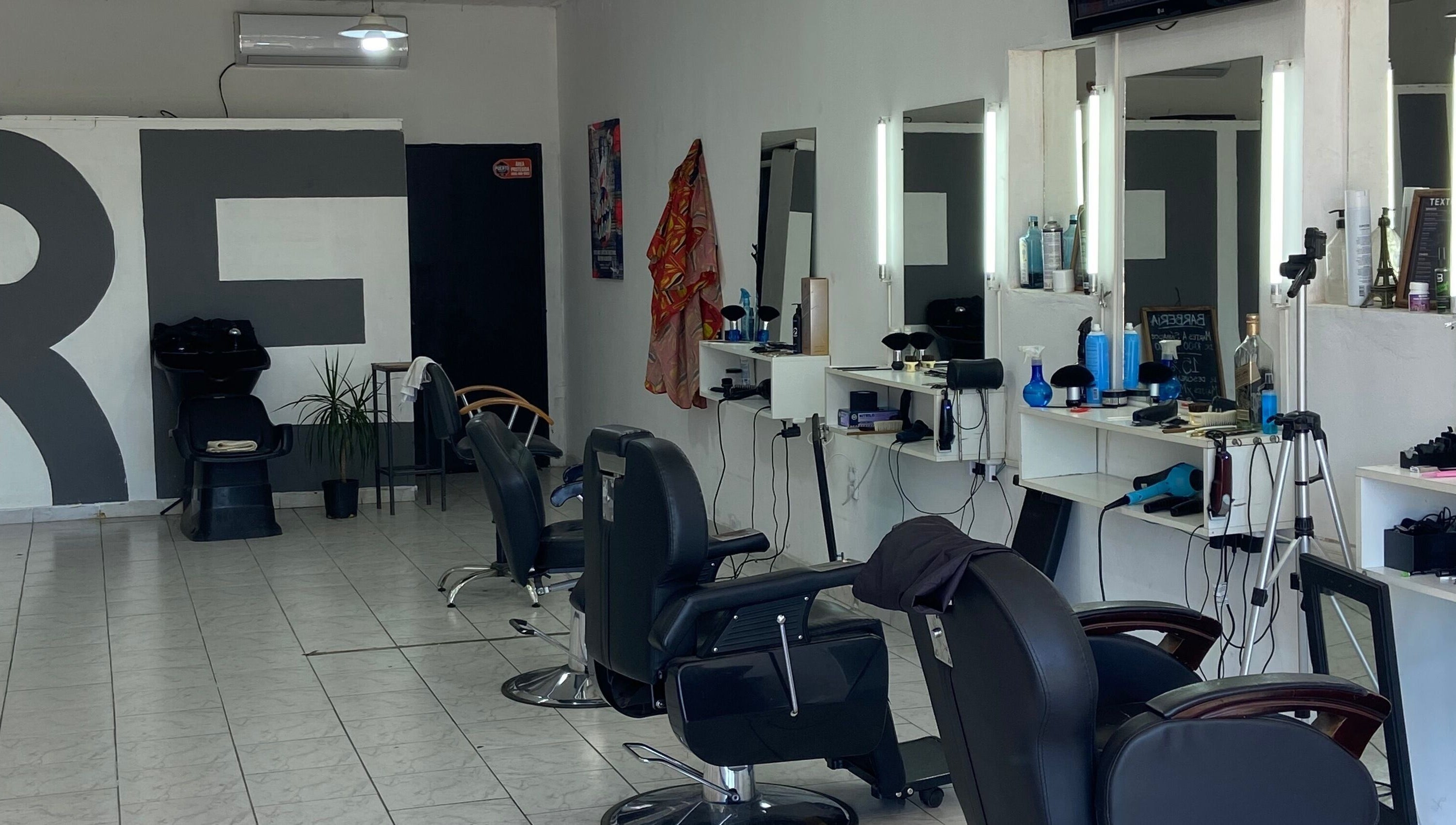 Interior de Texture Barbershop en Rosario, Santa Fe, AR, mostrando sillas y estaciones de estilismo.